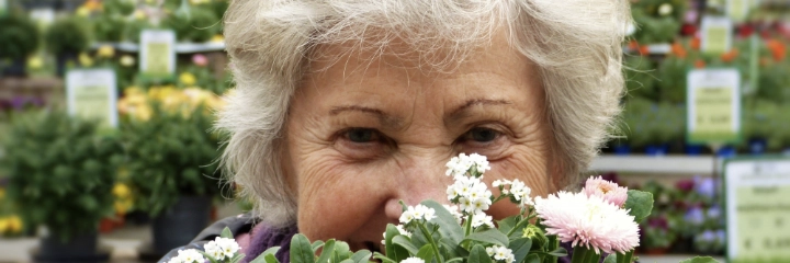 A woman sits smiling behind a bouquet of flowers